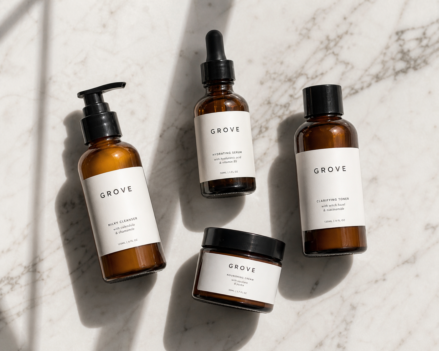GROVE product lineup — four amber glass bottles on white marble
